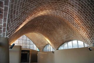 Inside a building with a curved arch-shaped ceiling made with bricks.