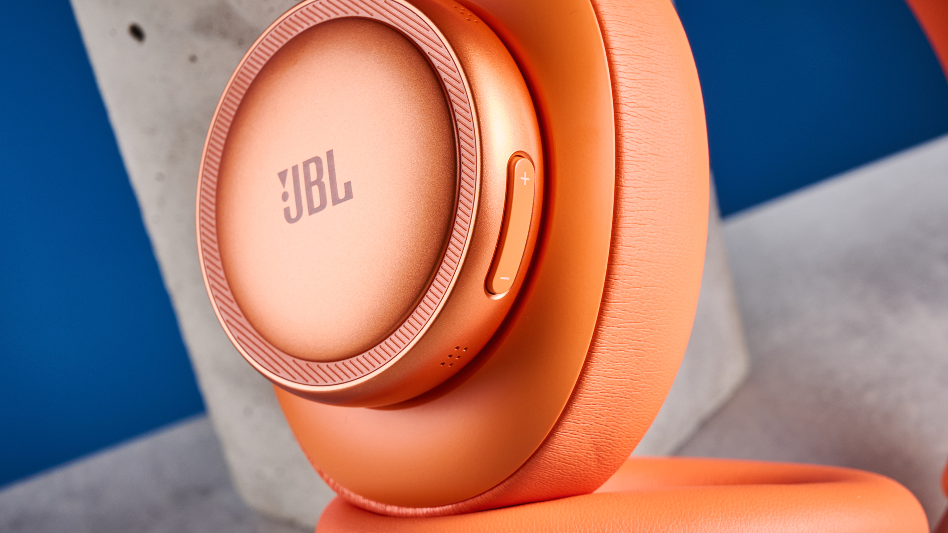the jbl live 780NC in orange photographed against the blue tom's guide background
