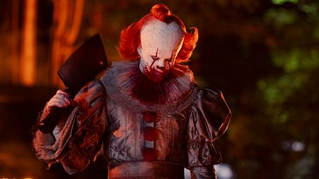 Bill Skarsgard as Pennywise holding a cleaver in IT: Welcome To Derry