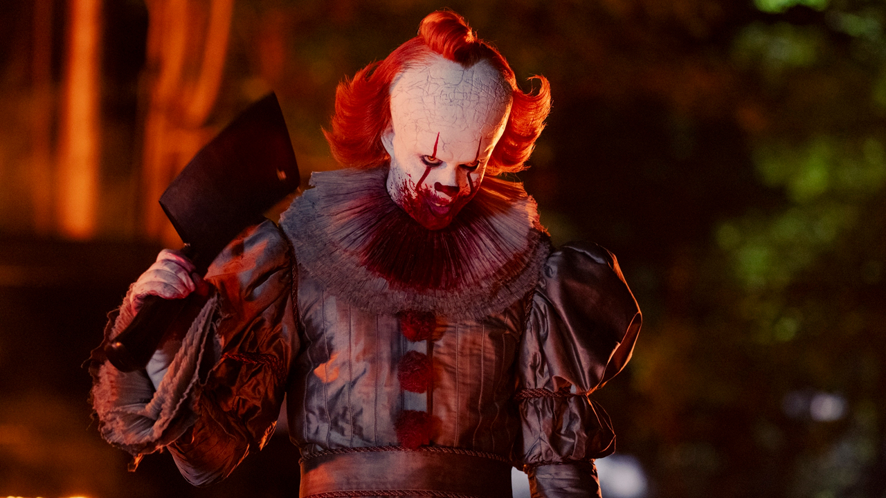 Bill Skarsgard as Pennywise holding a cleaver in IT: Welcome To Derry