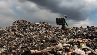 A man walking through a landfill site