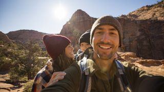 A family taking a selfie while hiking on a desert trail