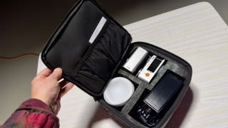 Zhiyun Molus X60 video light case with a hand opening the lid
