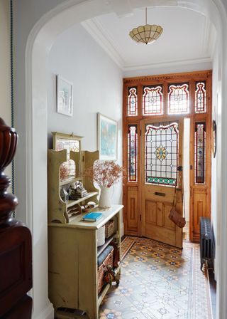 Victorian hallway with encaustic tiled floor and stained glass front door