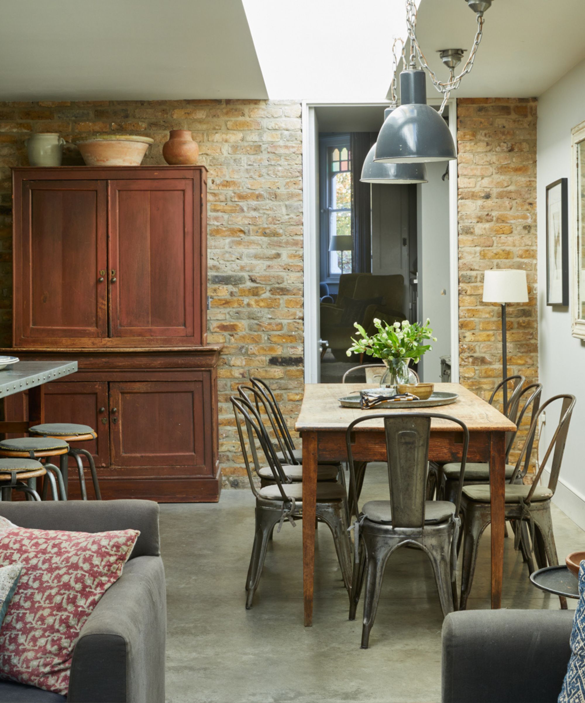 Cave Interiors kitchen with industrial pendant lights and metal cafe chairs