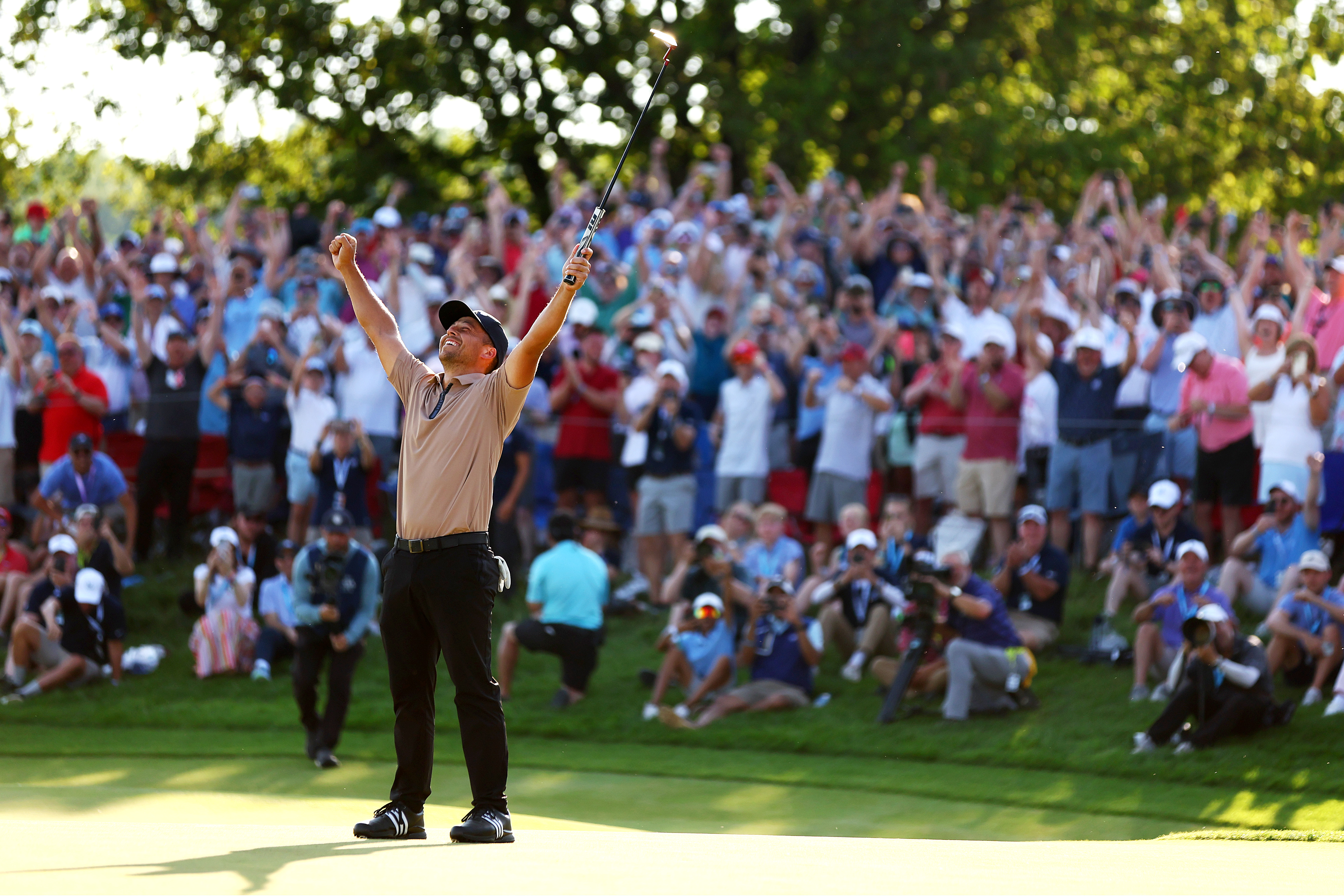 Xander Schauffele celebrates after holing the winning putt