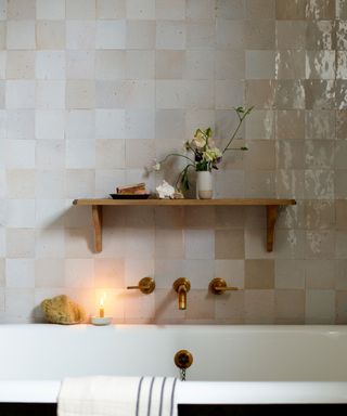 bathroom with tiled wall and wood bath shelf