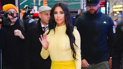 Kim Kardashian waves at the camera