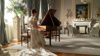 A woman playing a piano in Bridgerton, in a room decorated with Regency style