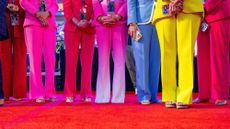 A group of women in colourful suits stand and watch US President Donald Trump speak during the Midterm Republican National Convention at the American Airlines Center in Dallas, Texas