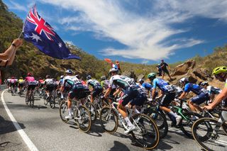 The Australian flag flies over the 2025 Tour Down Under peloton