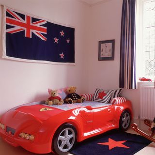 boys bedroom with car bed and wall flag