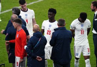 Bukayo Saka, centre, and Marcus Rashford, right, react after missing their penalties in the Euro 2020 final