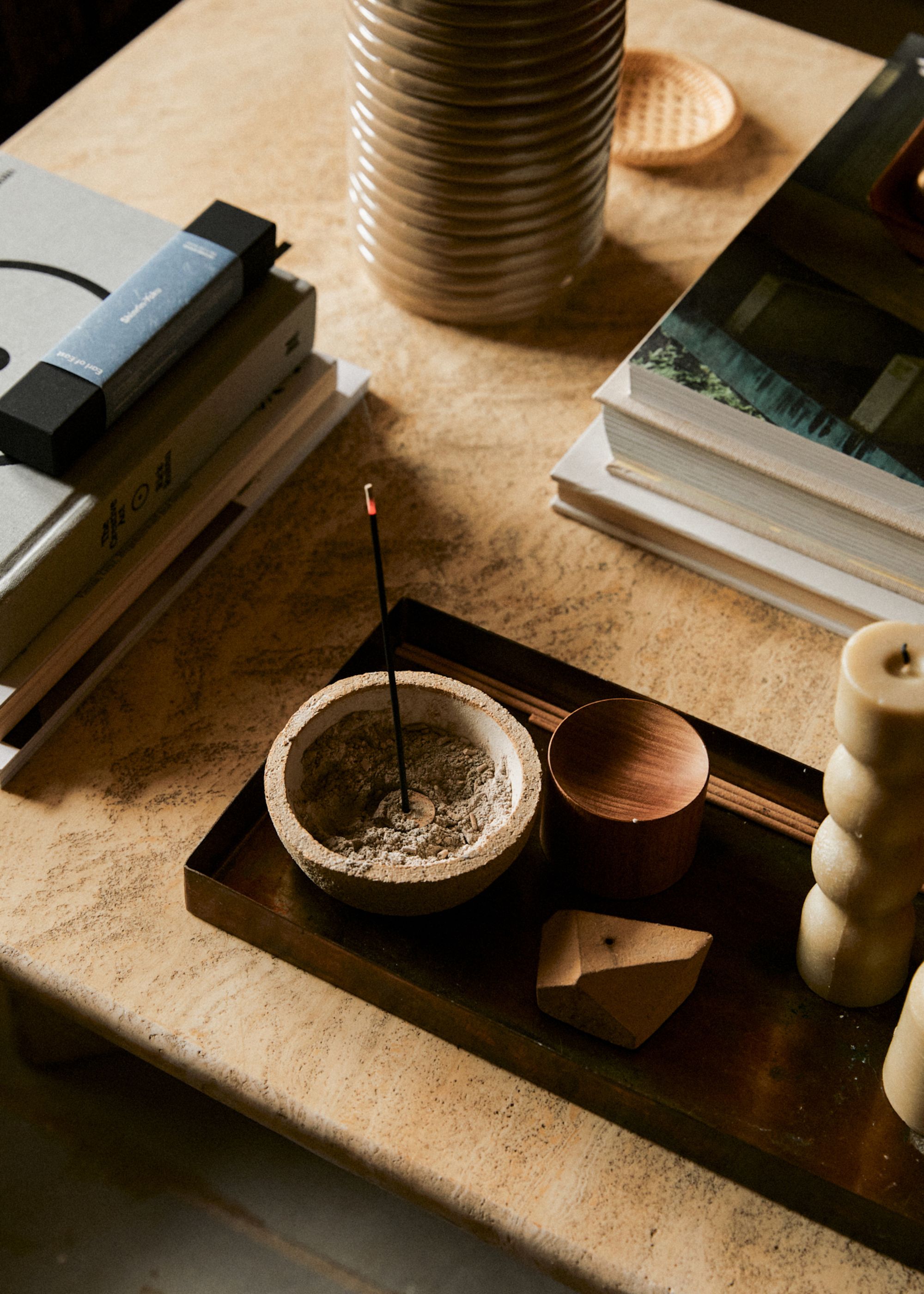 An incense stick from Earl of East burning on a coffee table