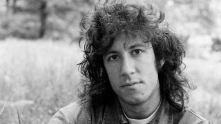 Peter Green of Fleetwood Mac posing for a photograph in a field in 1969