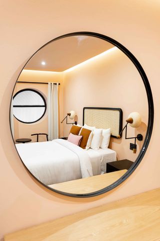 Room with 2 side tables, lamp fixtures and round window