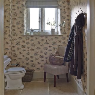 cloakroom with wallpaper and commode