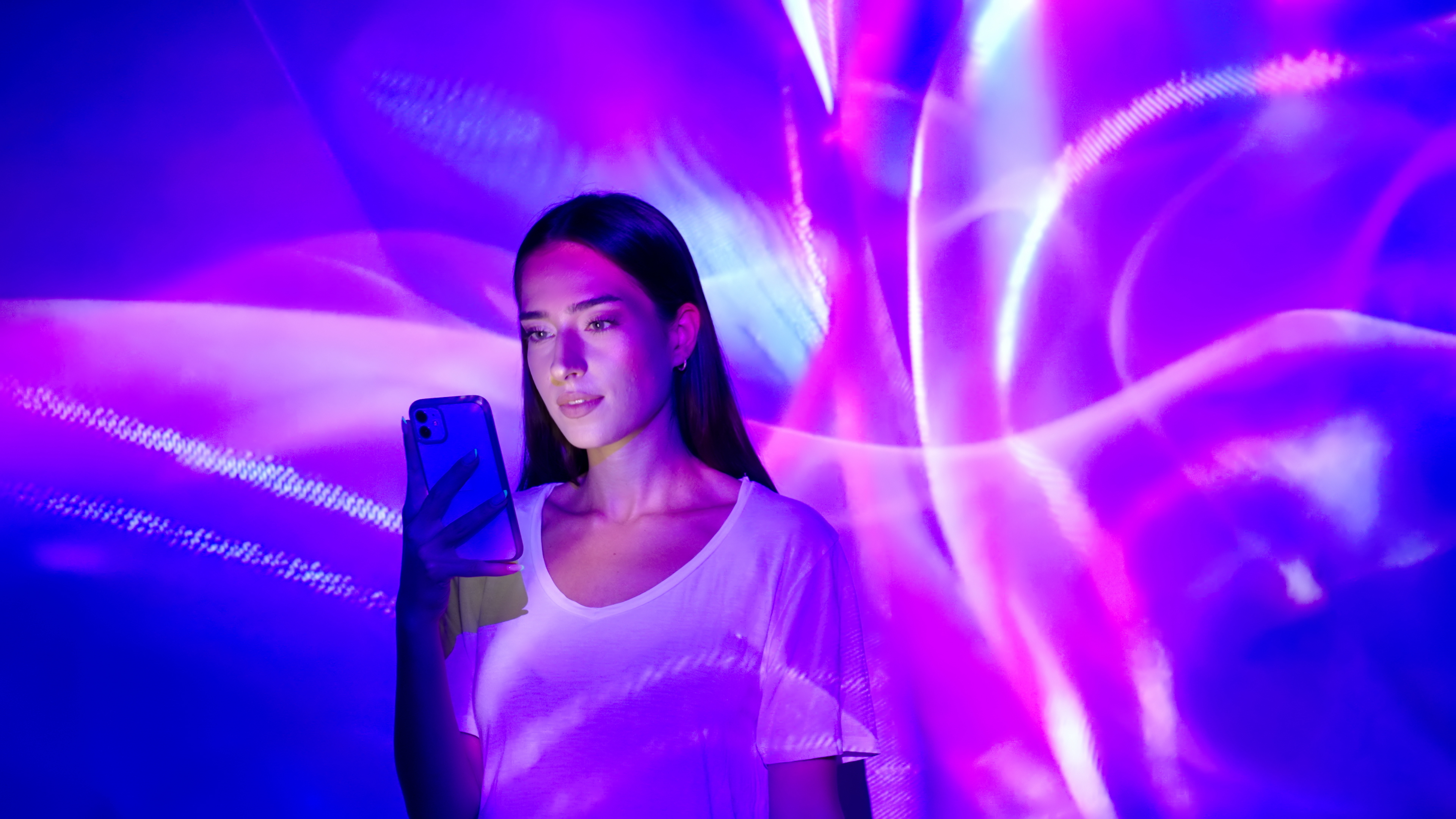Woman holding phone with pink neon lights