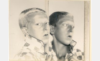 black and white photo of Claude Cahun, reflected in mirror
