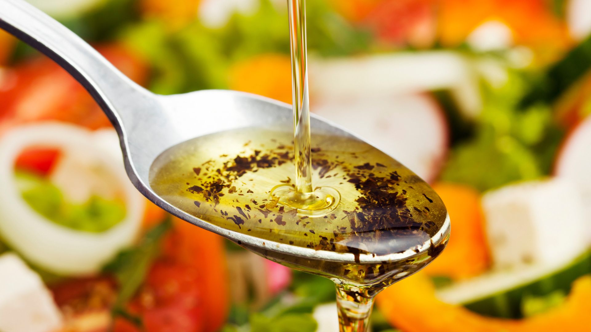 Infused olive oil being poured out onto metal spoon
