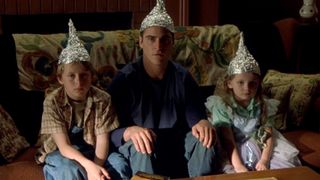 Joaquin Phoenix as Merrill Hess wearing a tinfoil hat in the sci-fi movie Signs.