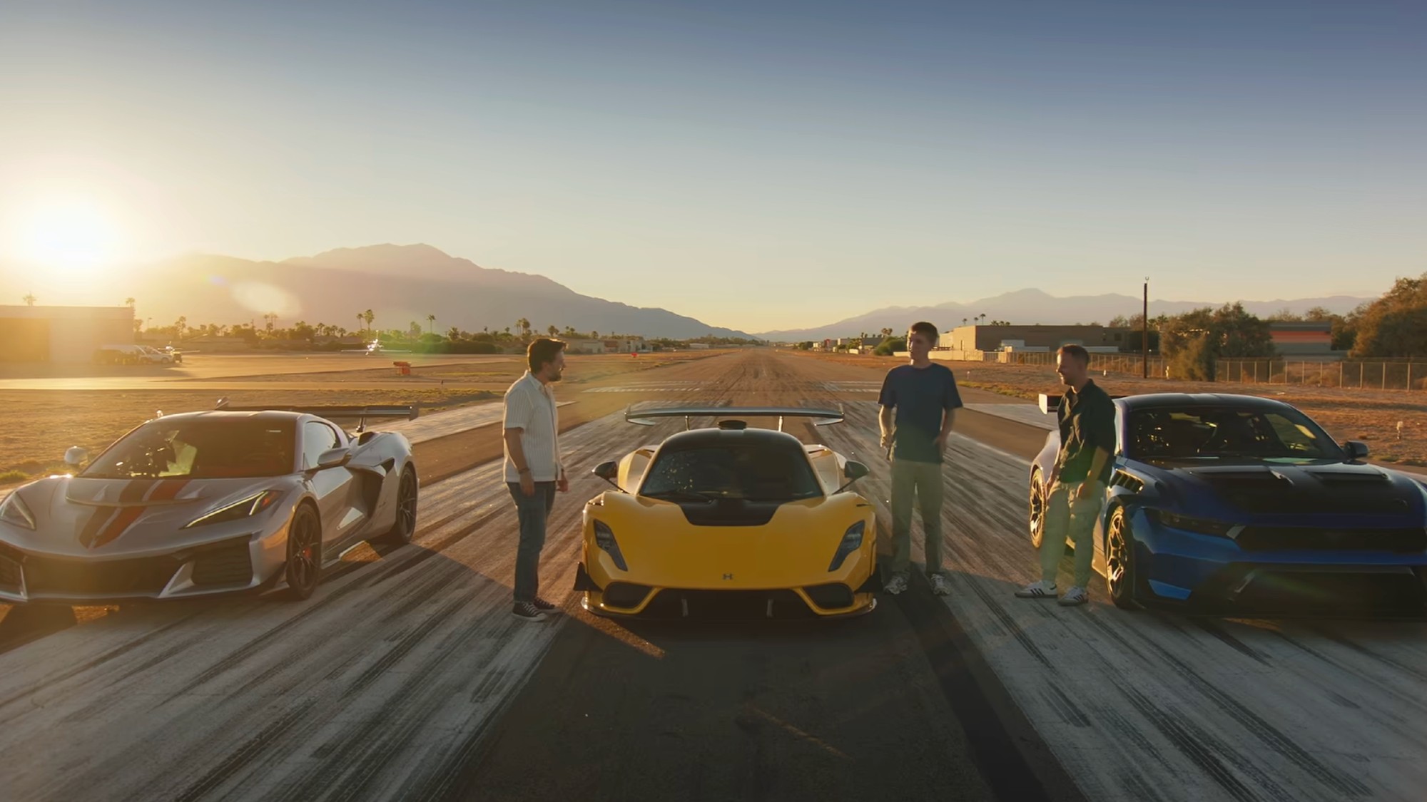 The three hosts of The Grand Tour standing by three sports cars