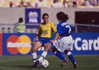 Sissi #10, Forward and Midfielder for Brazil dribbles the football past #20 Roberta Stefanelli, Defender for Italy during their Group B match of the FIFA Women's World Cup on 24th June 1999 at Soldier Field in Chicago, Illinois, United States. Brazil won the game 2 - 0. (Photo by Matthew Stockman/Allsport/Getty Images)
