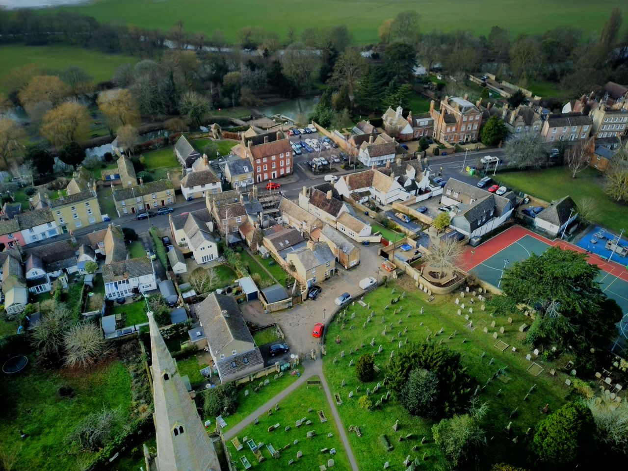 Drone shot of a small town surrounded by green countryside