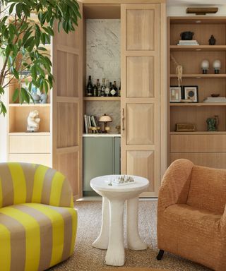 living room with striped chair and home bar cupboard