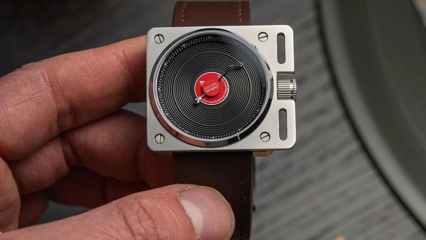 The Ando Ando Ando Vinyl Record Watch with a brown leather strap being held in the hand.