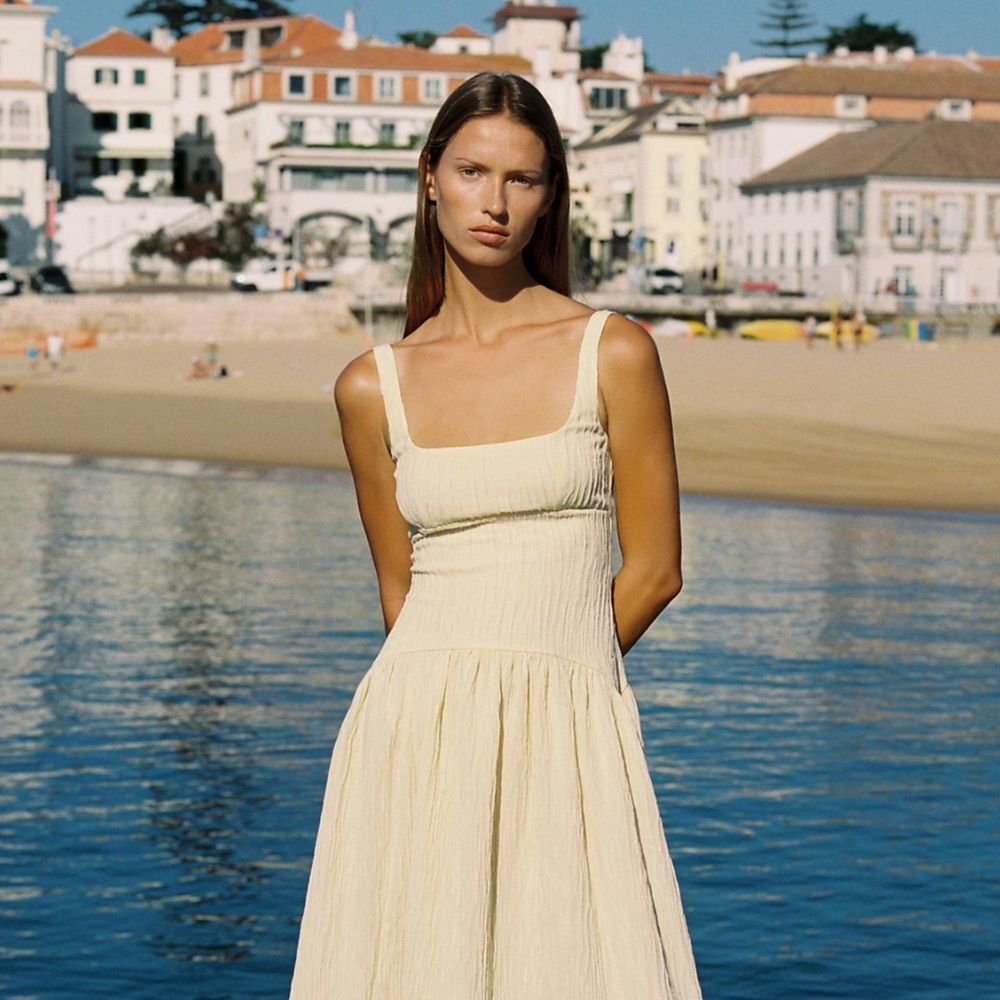 Woman wears yellow pleated dress