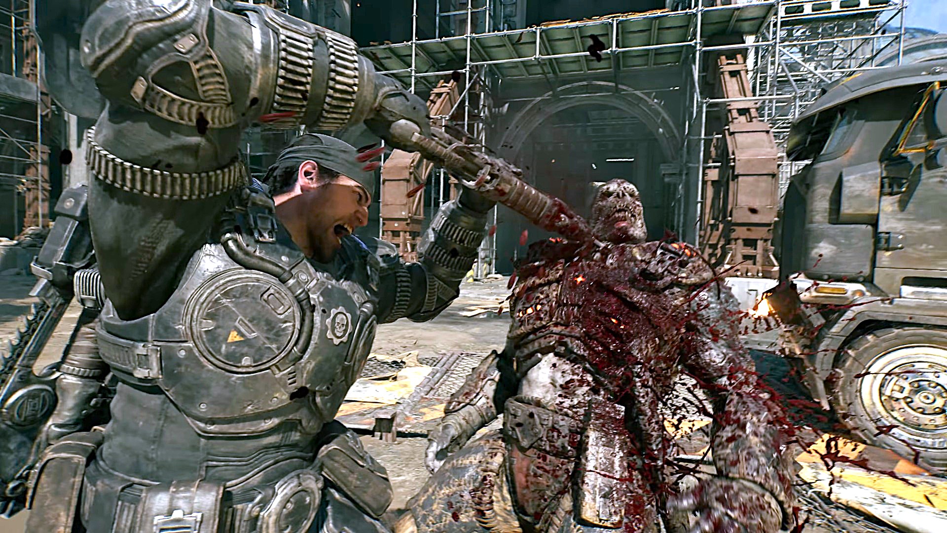An armored soldier swings a weapon at a bloodied creature in a wrecked industrial yard, amid flames and metal debris; the scene feels violent and chaotic.