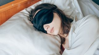 woman asleep wearing a silk eyemask enjoying silk pillowcase benefits while she sleeps