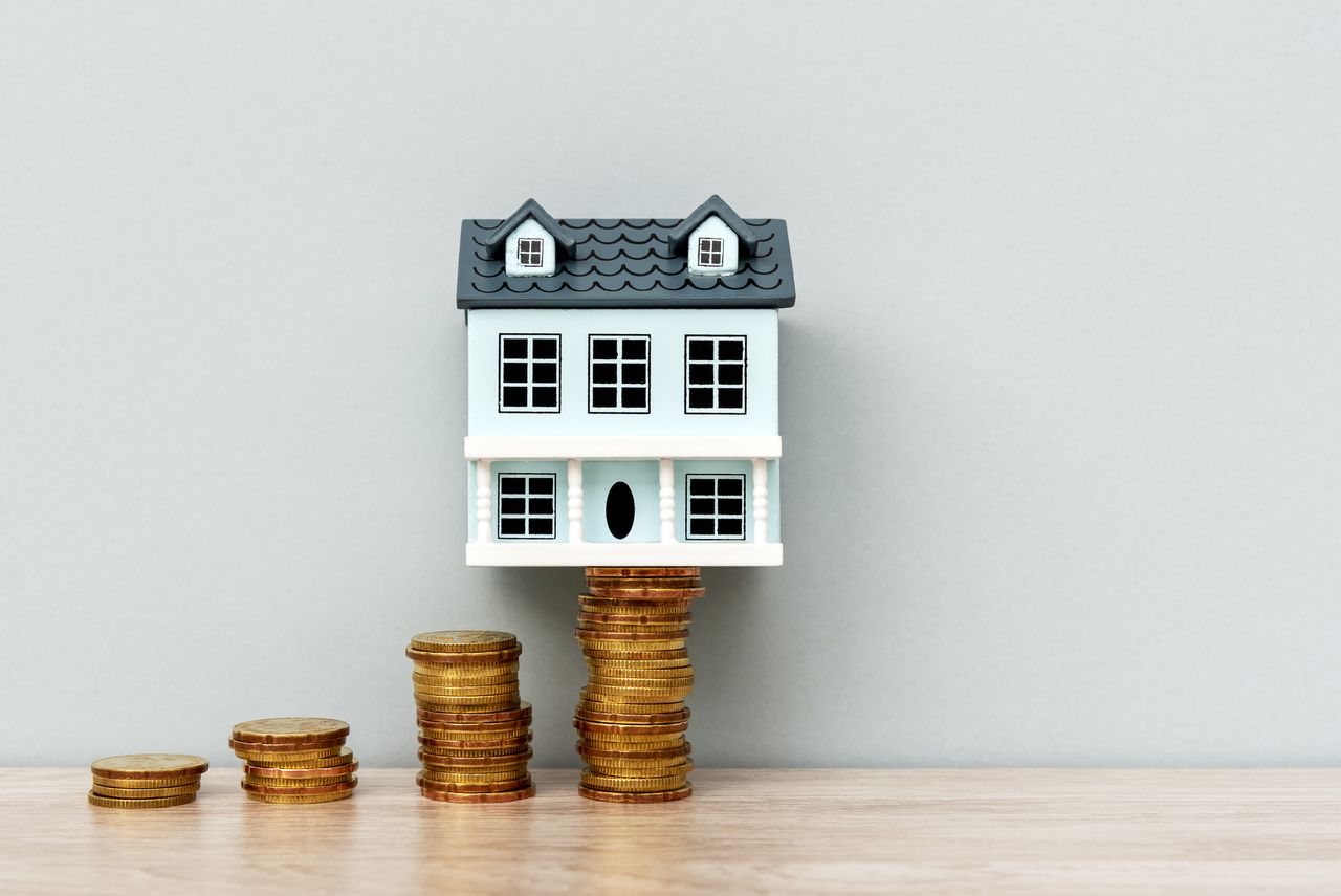 House model on top of stack of coins