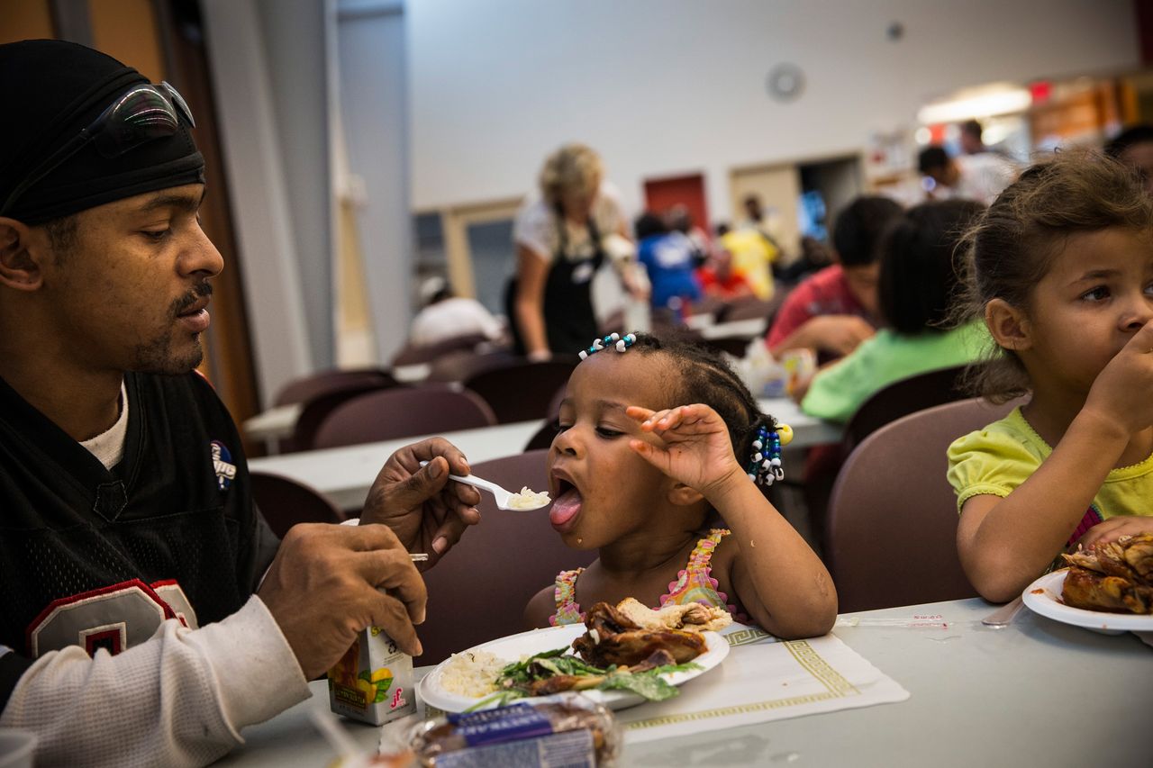 LeManuel Farrish helps his cousin finish dinner at a soup kitchen in Camden, New Jersey.