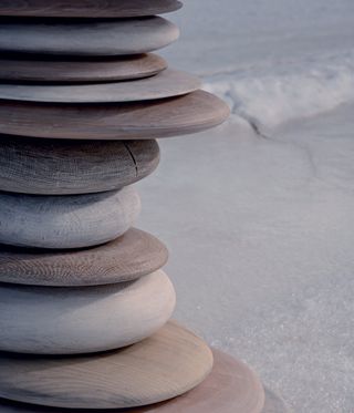 Close up view of a pile of carved wood pieces that look like big, smooth stones