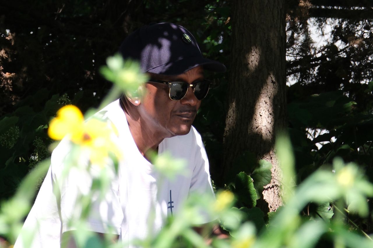 A man in sunglasses sitting down in the sun