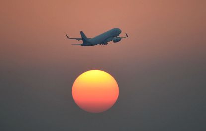 An airplane and the setting sun.