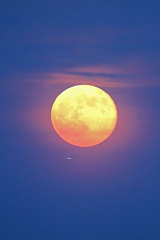 Veteran night sky photographers Edwin Aquirre and Imelda Joson took this amazing photo of the supermoon full moon rising through haze over downtown Boston on June 23, 2013.