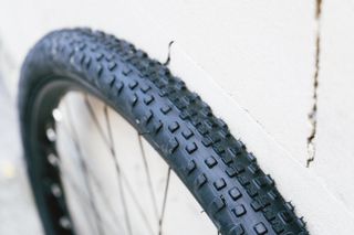 A black gravel tyre against a white stone wall