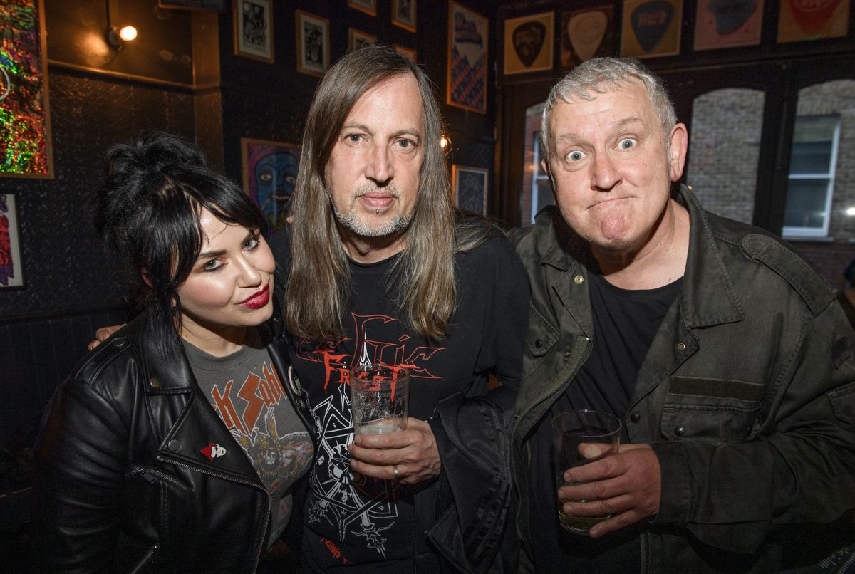 People drinking, smiling and throwing horns at the Metal Hammer 400 party