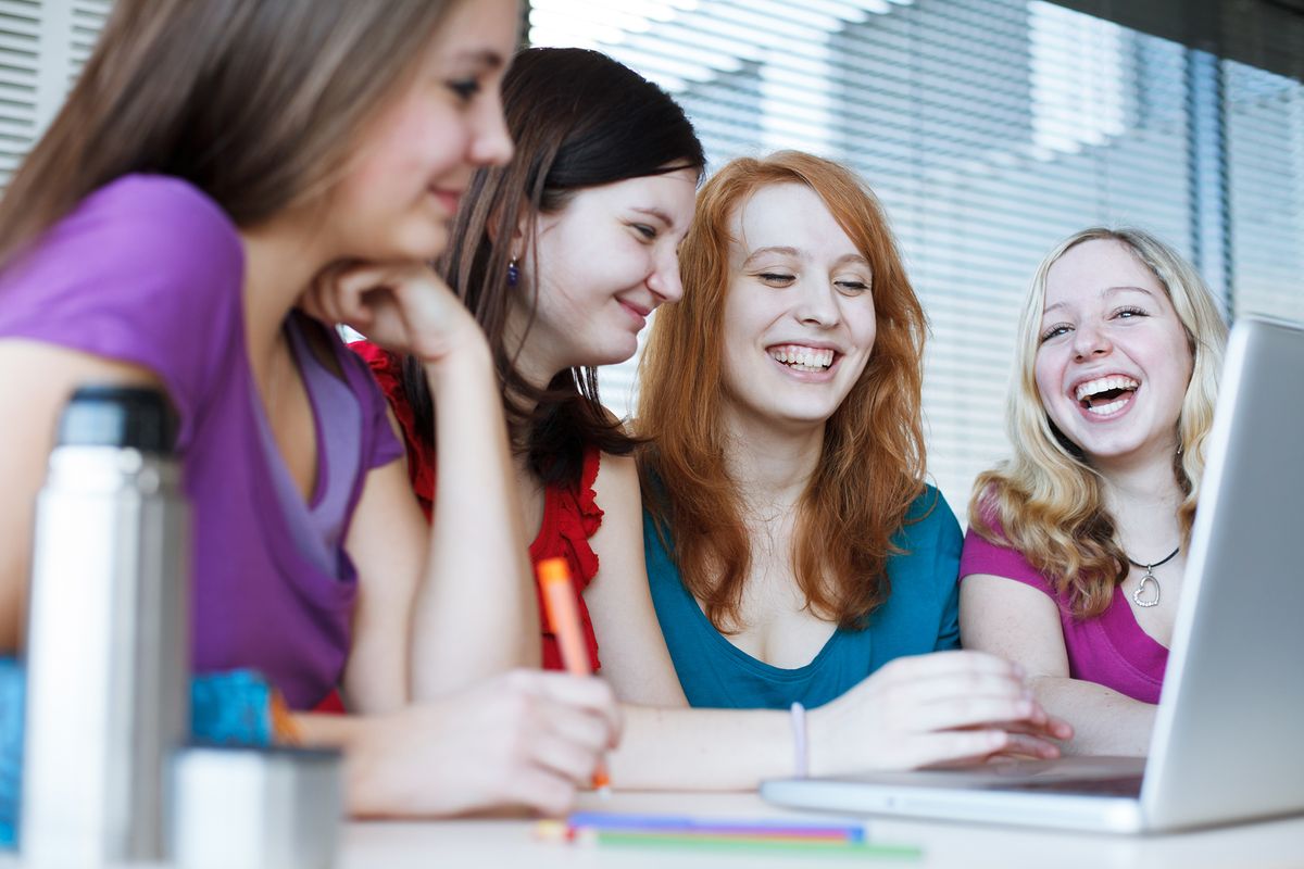 Students gathered around a laptop