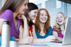 Students gathered around a laptop