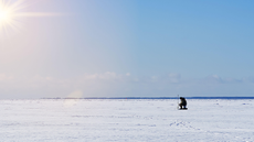 A person ice fishing at sea in Estonia