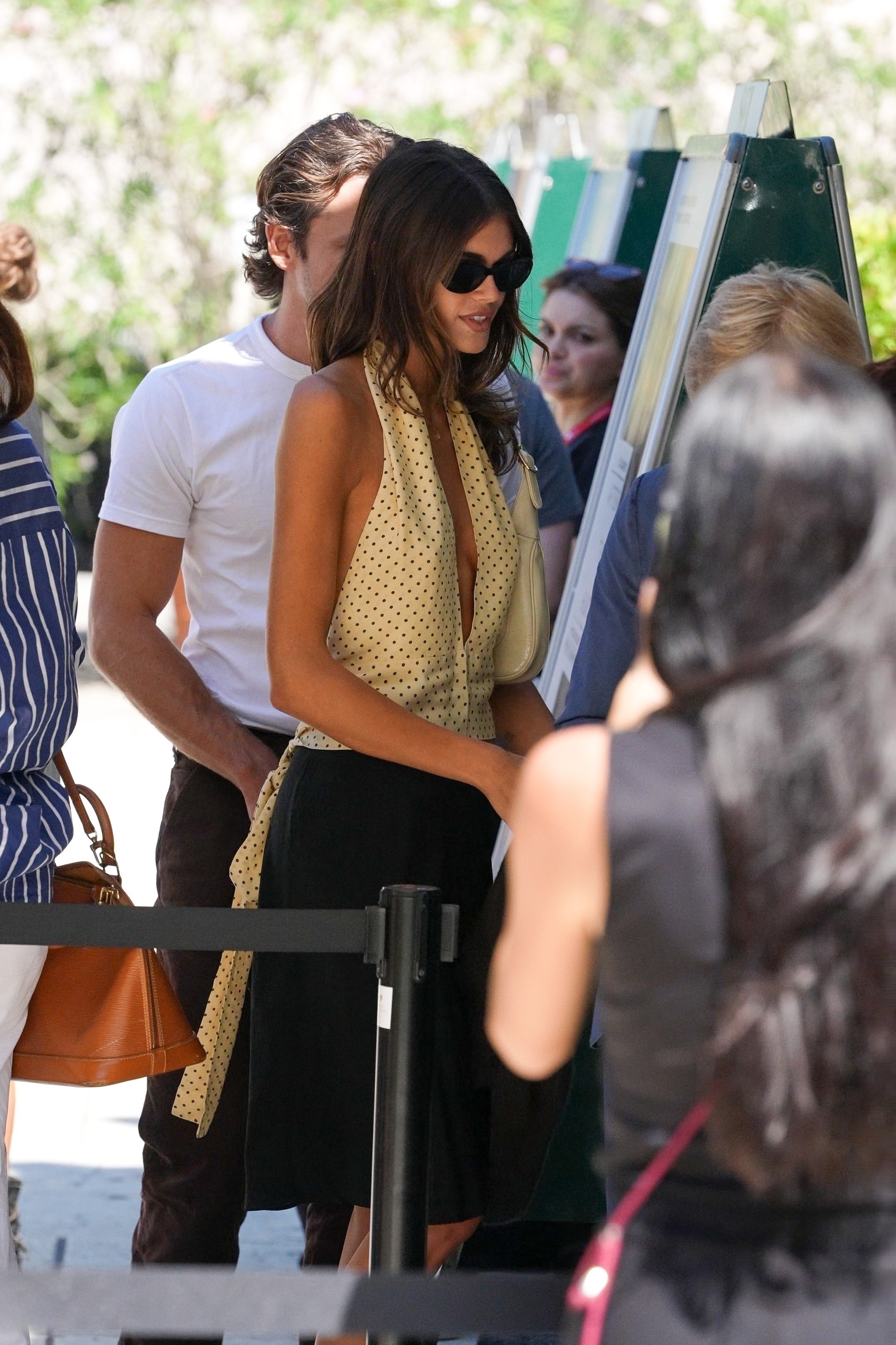 Kaia Gerber wears a polka dot halter top and carries a Gucci Jackie 1961 bag