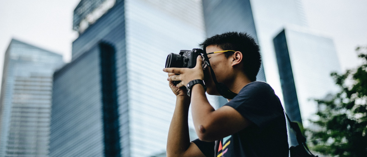 Man in a city taking a photograph