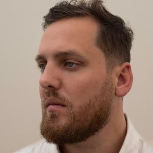 Close-up image of a man's face with a beard.