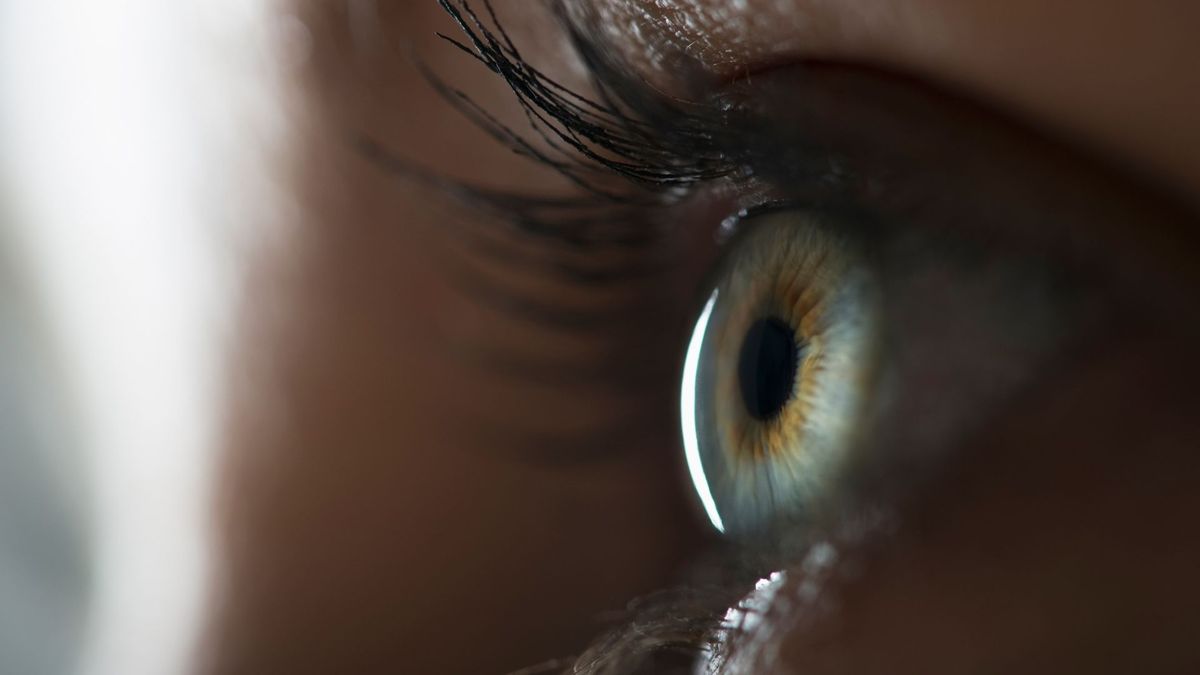 close up on a woman&#039;s eye in a dimly lit room