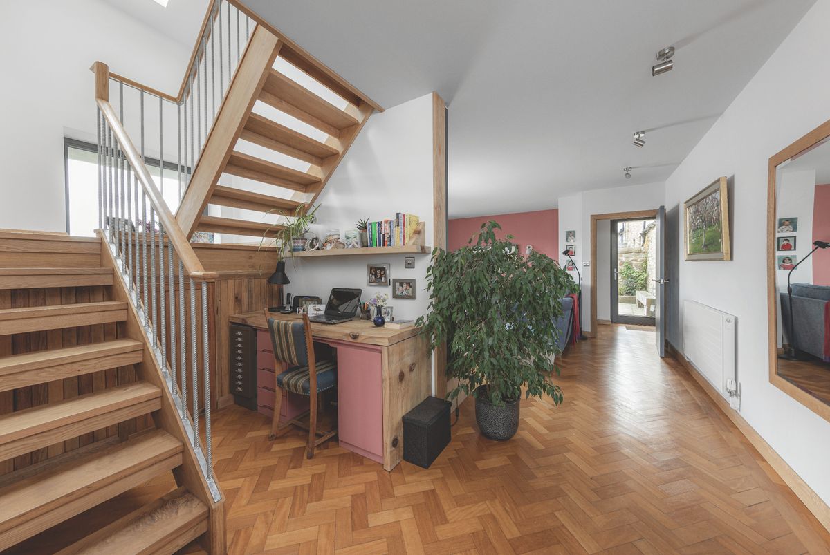 A modern barn conversion with a home office setup and parquet flooring