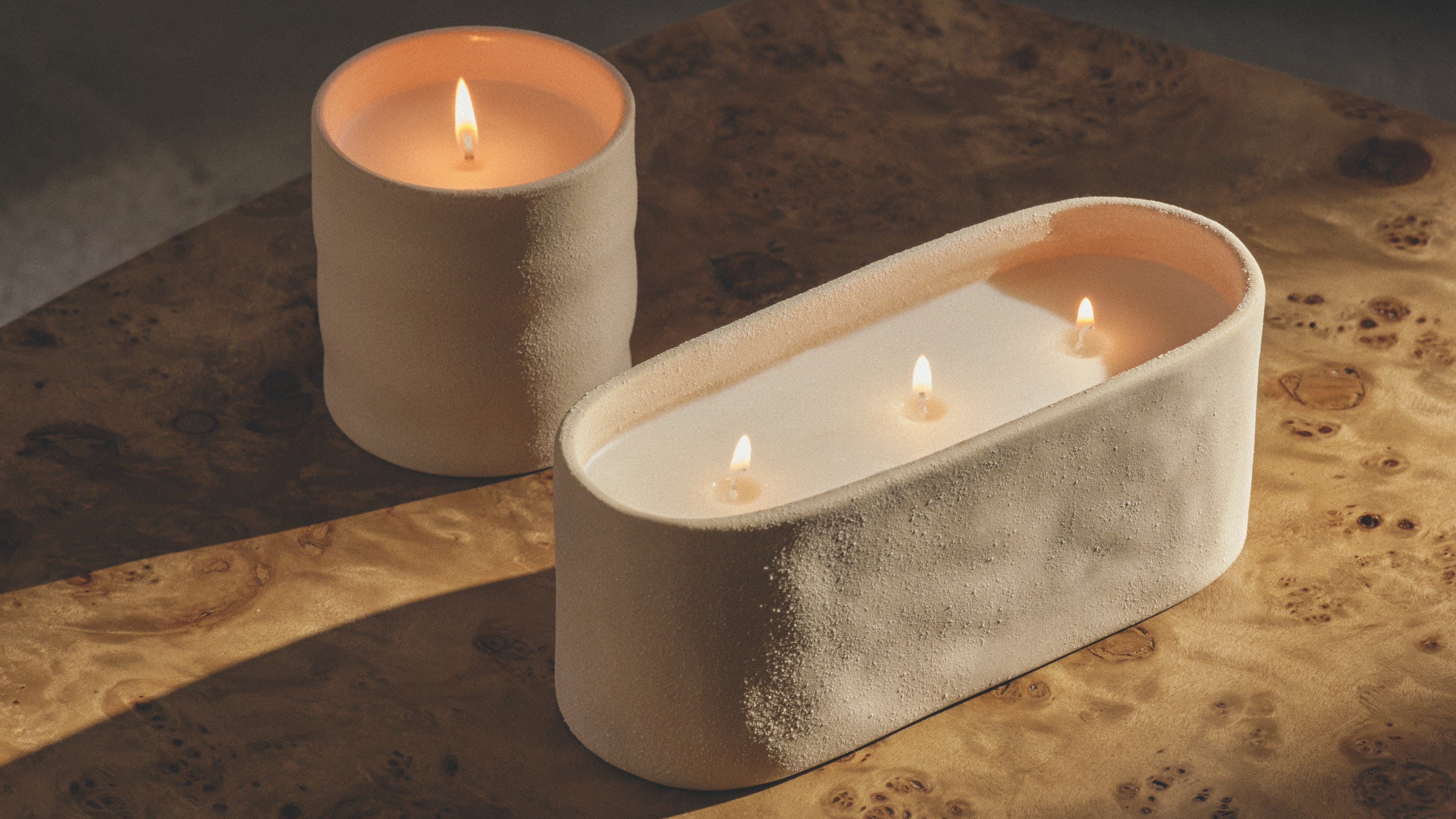 M&amp;S new 1 wick and 3 wick ceramic candles on a burl wood table.